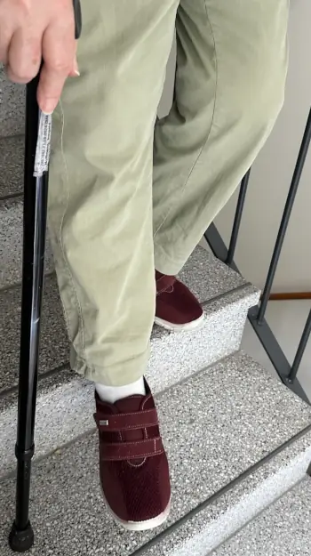Geriatrie: Eine ältere Person geht mit einem Stock eine Treppe herunter.