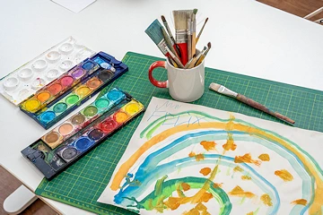 Malutensilien und ein Tuschebild auf einem Tisch